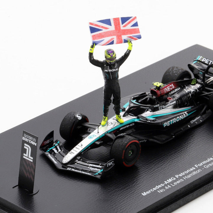 Model Formula 1 car with a driver figure and British flag on a black display stand.